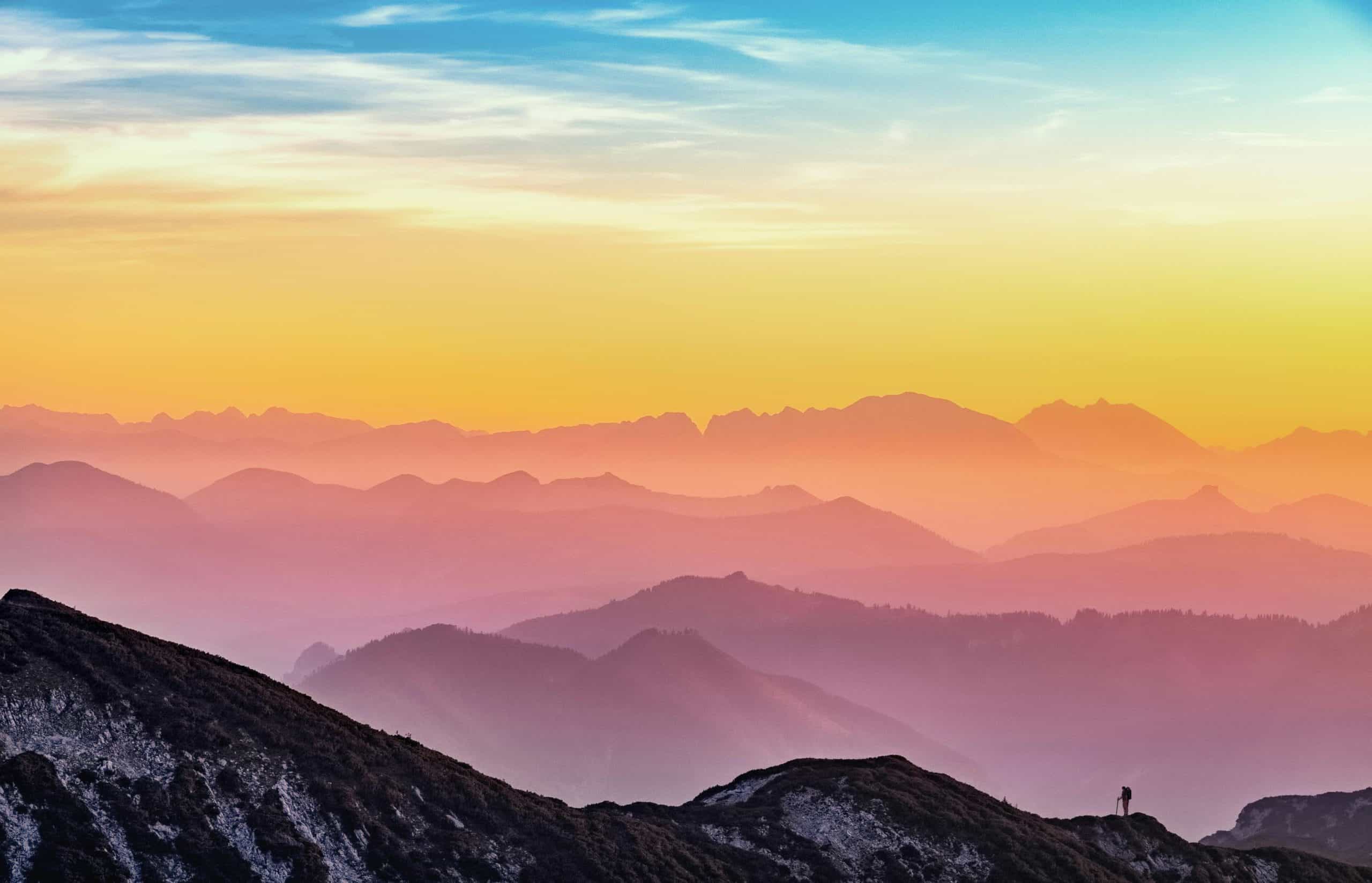 Colorful sunrise over mountains symbolizing clarity and abundance.